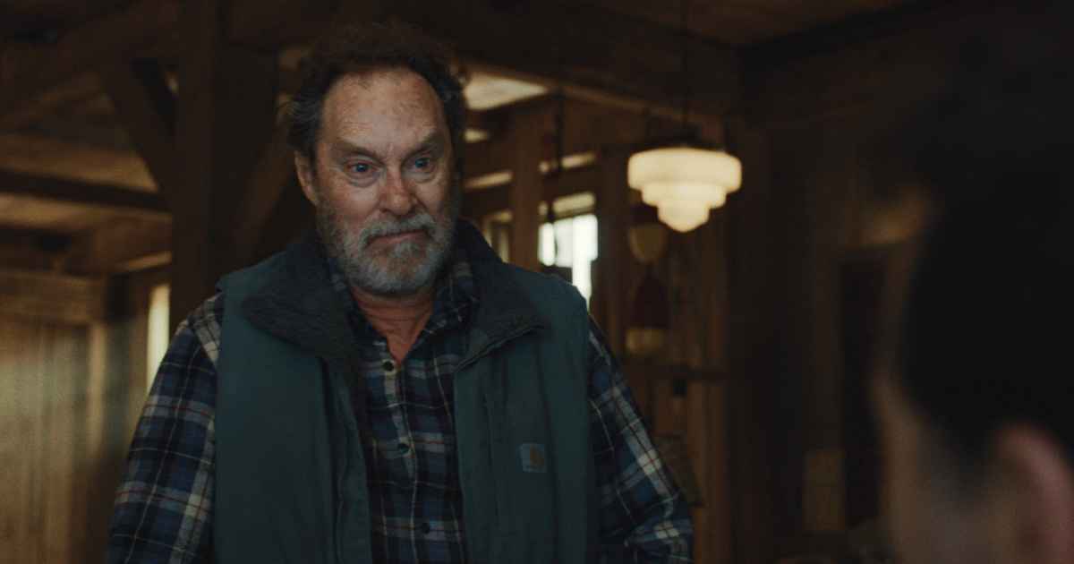 man in vest and flannel shirt with beard
