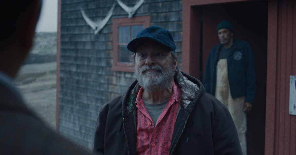 man with hat and beard standing outside in a nautical town